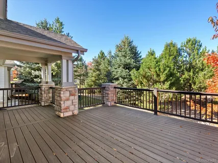 a balcony with wooden floor table and chairs