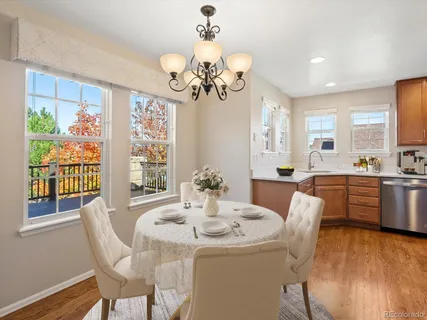 a view of a dining room with furniture a chandelier and wooden floor