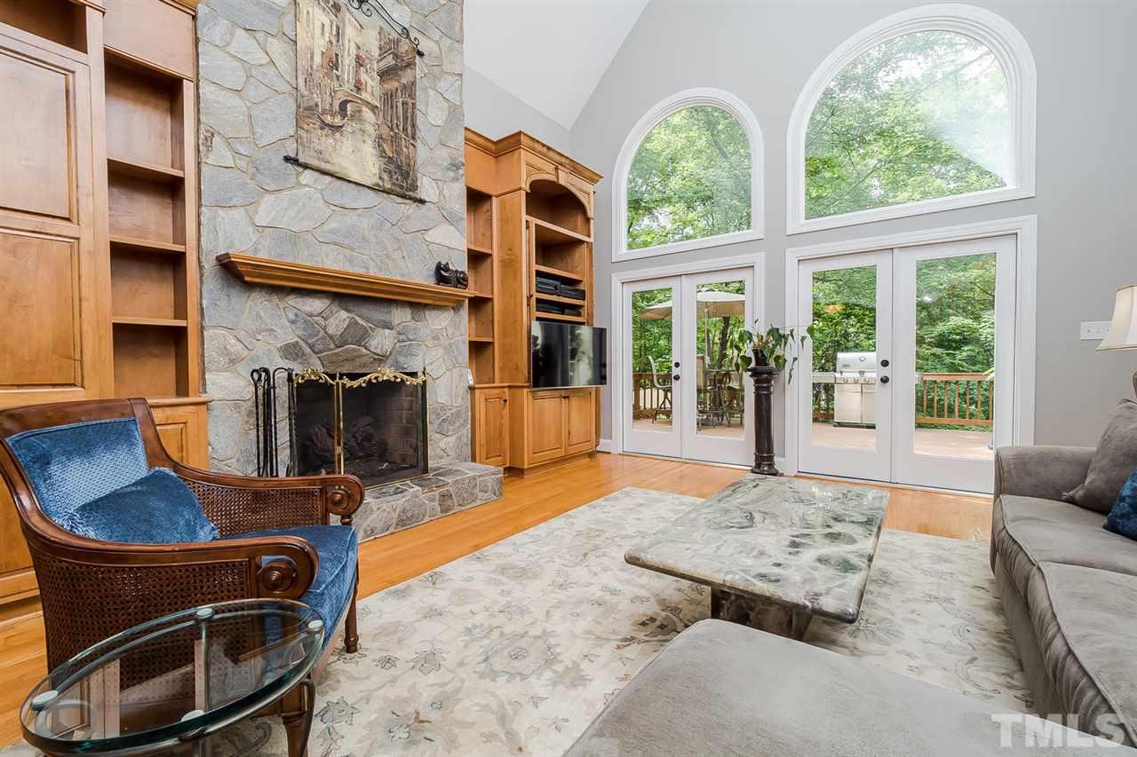 1105 Wagon Ridge Road Raleigh, NC 27614 - Photo 5 of 25 Great Room with wall of windows, masonry fireplace, vaulted ceiling with fan, wet bar in cabinet, and double french doors leading to oversize deck. Custom Plantation shutters are available.