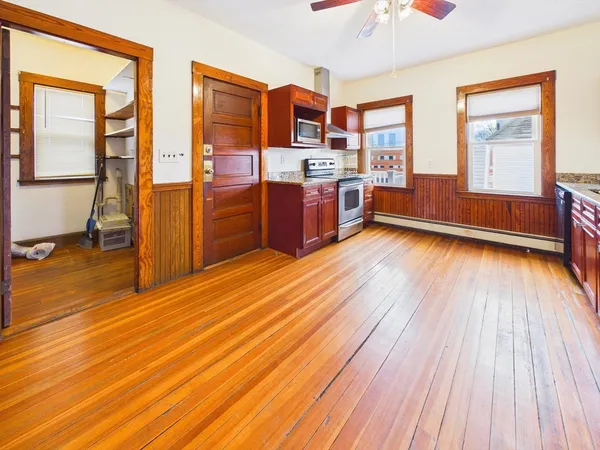 a view of a kitchen with wooden floor and electronic appliances