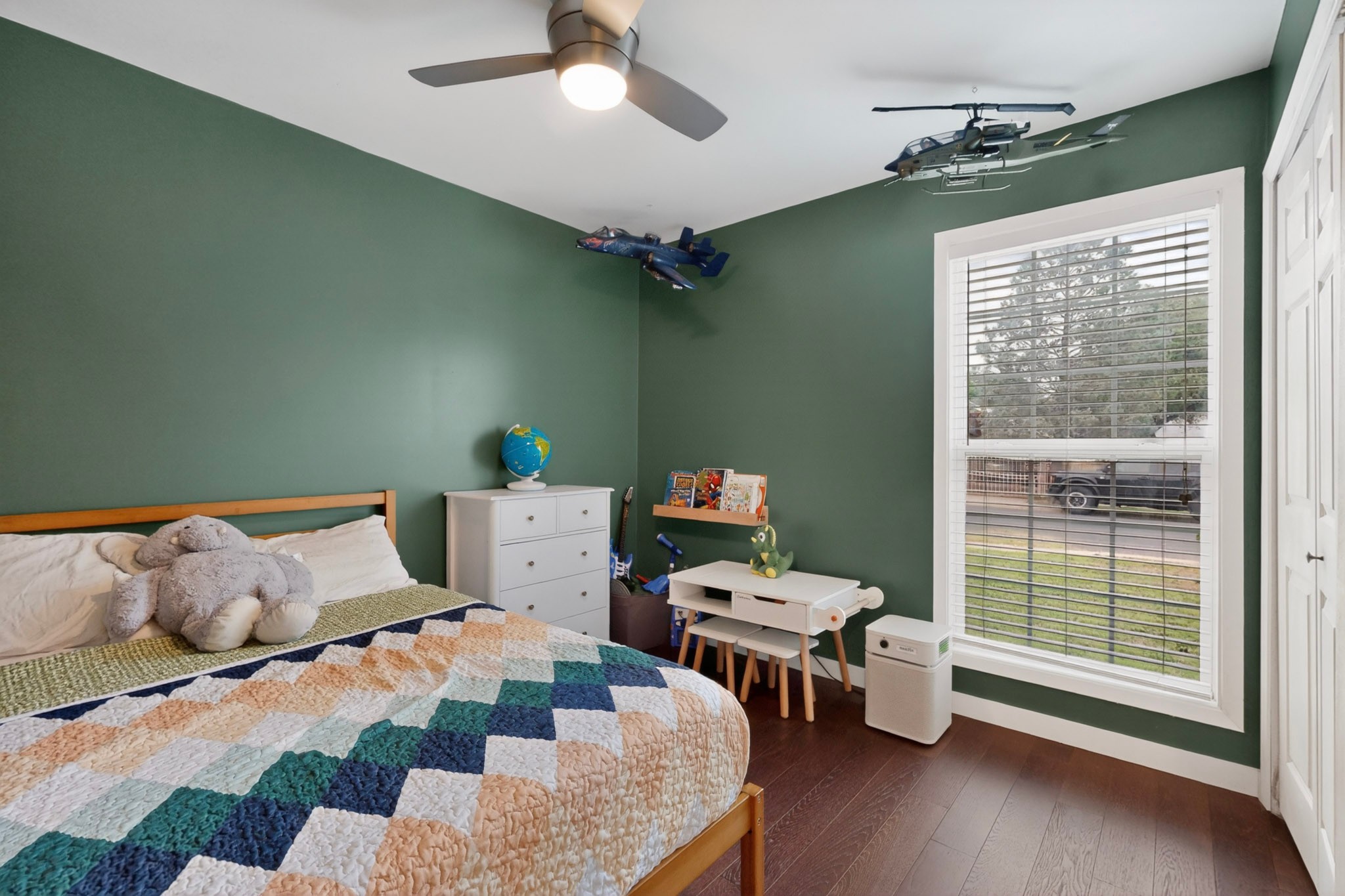 5541 Pine Place Austin, TX 78744 - Photo 22 of 33 Interior room featuring hardwood flooring, a ceiling fan with integrated lighting, and a white-trimmed window with blinds