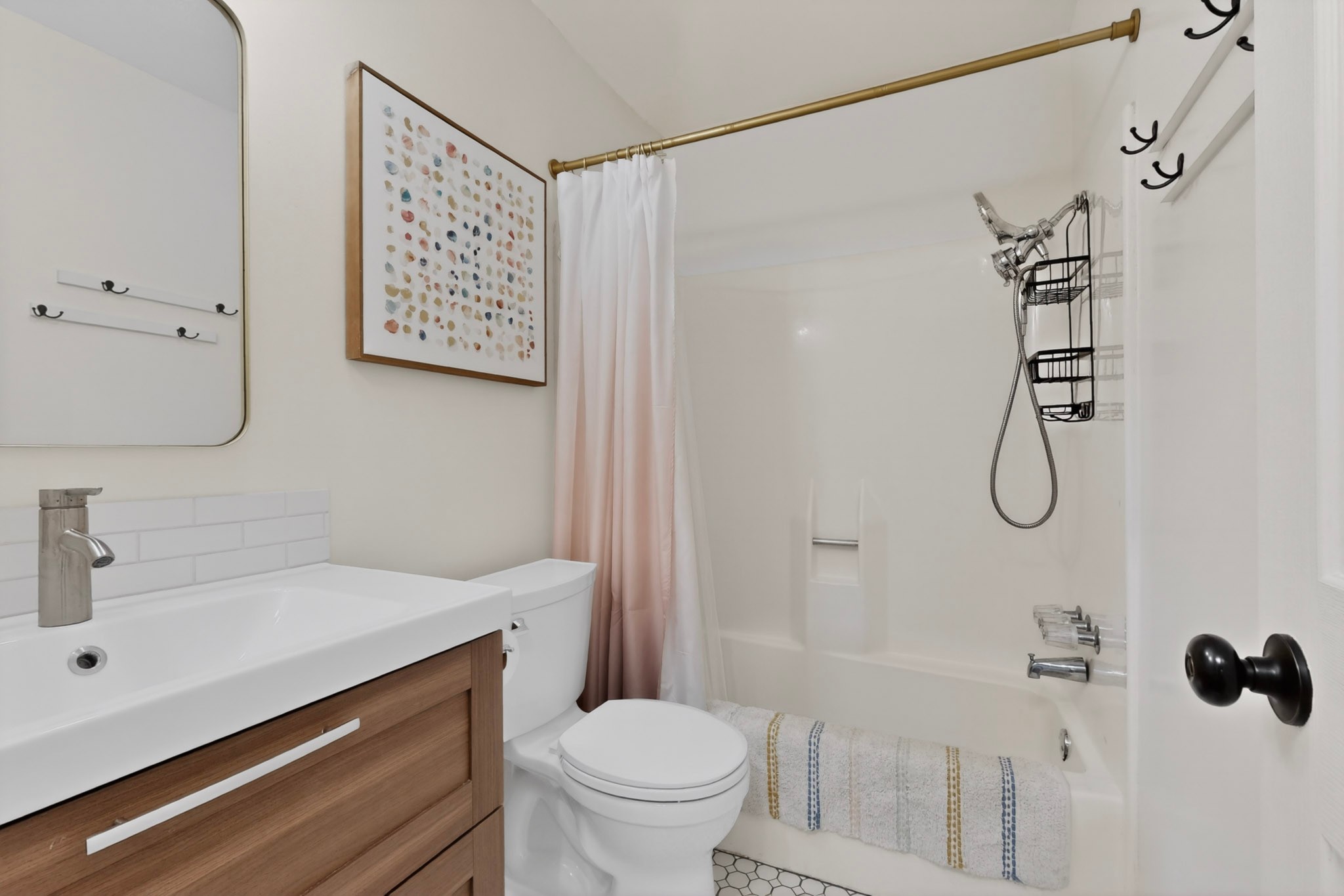 5541 Pine Place Austin, TX 78744 - Photo 26 of 33 Bathroom featuring a white subway tile backsplash, wood-finish vanity, and a tub with an integrated shower