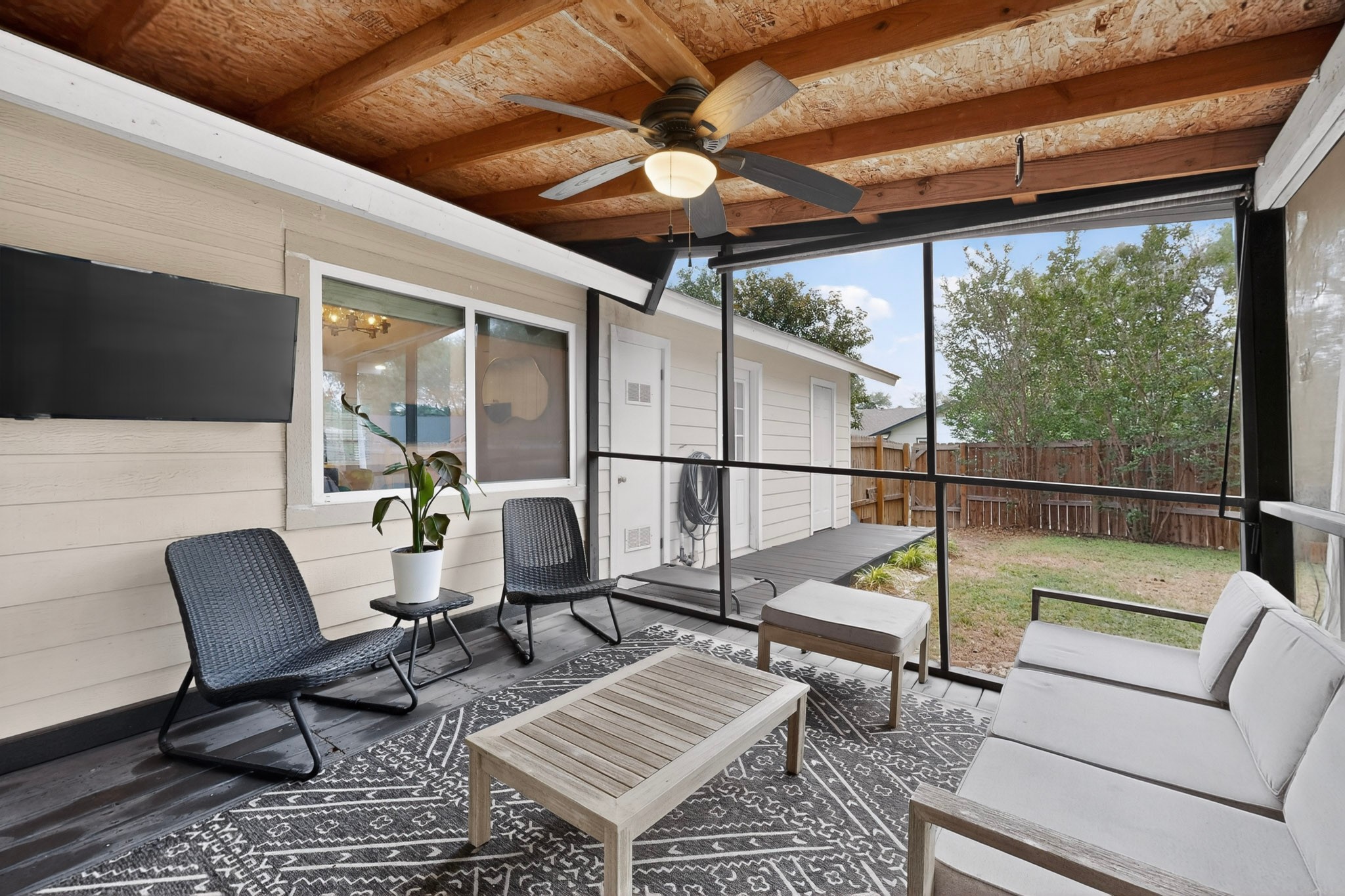 5541 Pine Place Austin, TX 78744 - Photo 29 of 33 Screened outdoor patio featuring a wood-panel ceiling, ceiling fan with integrated lighting, and a mounted flat-screen