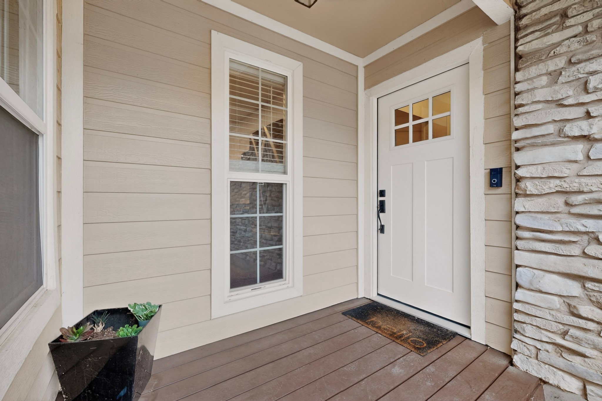 5541 Pine Place Austin, TX 78744 - Photo 4 of 33 Inviting entryway featuring a white paneled door with divided lites, horizontal siding, and natural stone veneer accents