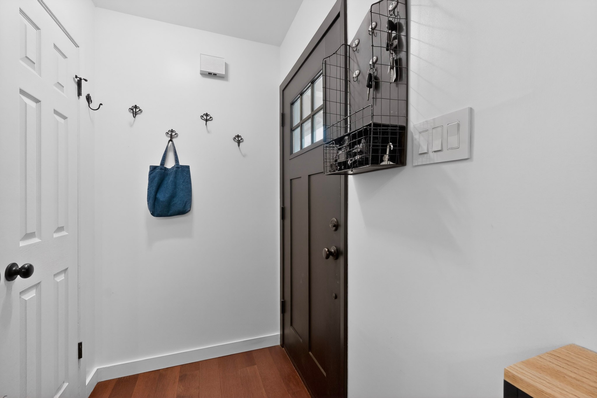 5541 Pine Place Austin, TX 78744 - Photo 5 of 33 Entryway featuring wood-finish flooring, a dark-stained door with frosted glass panel, and white baseboards