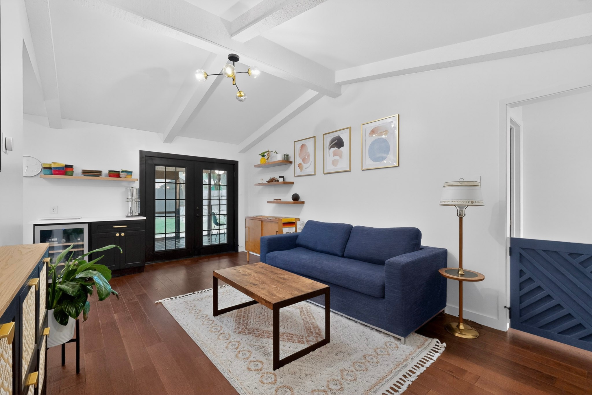 5541 Pine Place Austin, TX 78744 - Photo 8 of 33 Living space featuring wood-finish flooring, a vaulted ceiling with exposed beams, and a modern chandelier