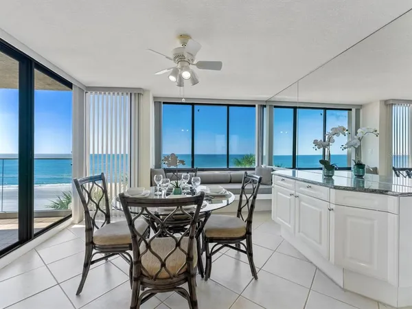 a dining room with furniture and a floor to ceiling window