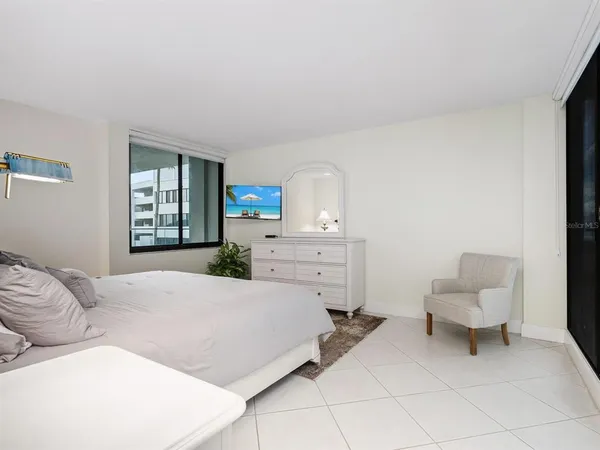 a bedroom with a bed and a potted plant