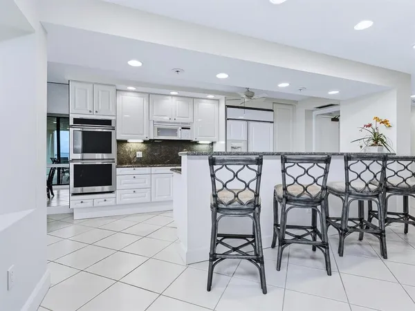 a kitchen with granite countertop white cabinets stainless steel appliances and a sink