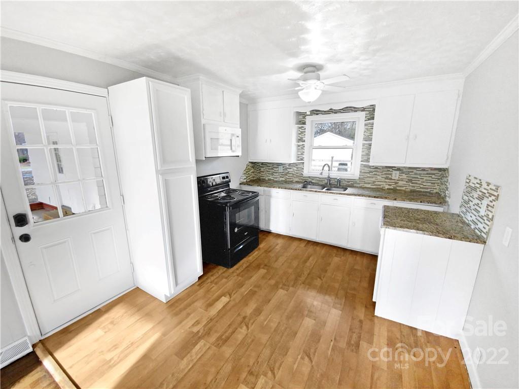 4408 Griffith Road Monroe, NC 28112 - Photo 6 of 17 a kitchen with stainless steel appliances granite countertop a stove a sink and a refrigerator