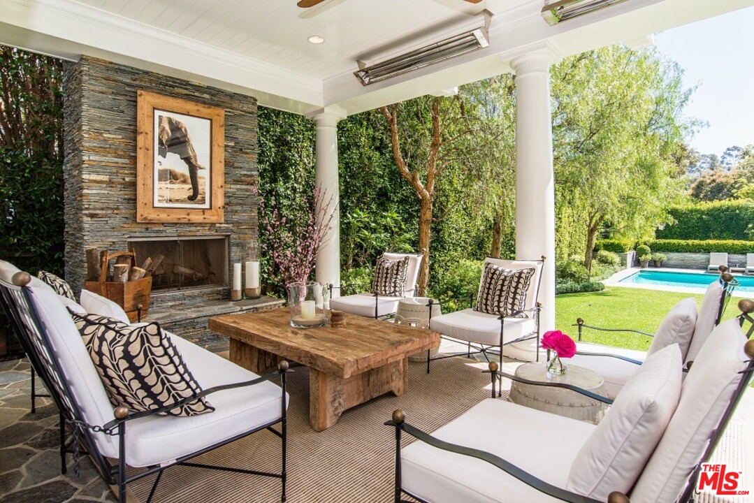 826 Greentree Road Pacific Palisades, CA 90272 - Photo 25 of 29 a view of a patio with dining table and chairs with wooden floor and fence