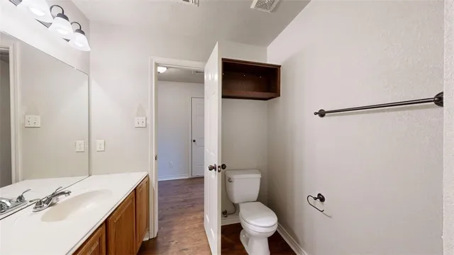 a bathroom with a toilet a sink and mirror