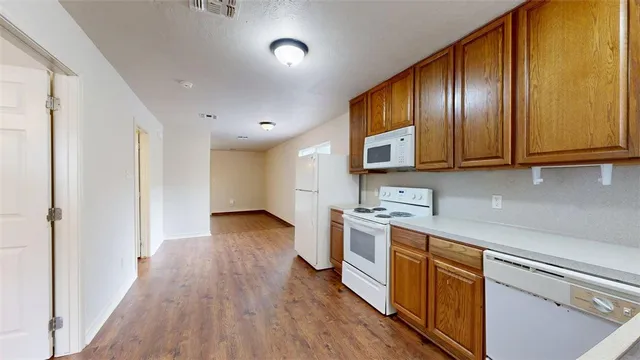a kitchen with stainless steel appliances granite countertop wooden cabinets a stove top oven a sink and dishwasher