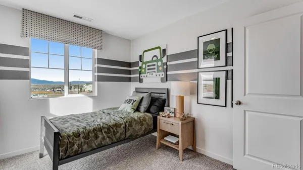 a bedroom with a bed a window and potted plant on the table
