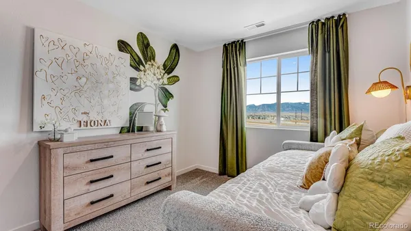 a bedroom with a bed and a dresser with a window
