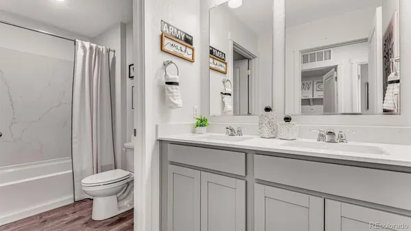 a bathroom with a double vanity sink toilet and shower