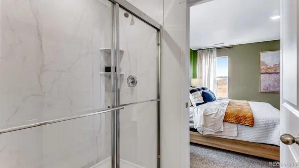 a bedroom with a bed and a refrigerator