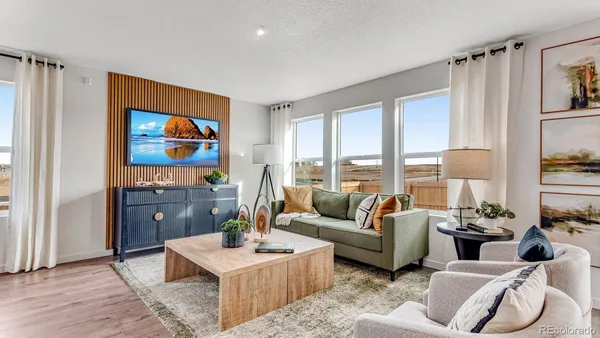 a living room with furniture a large window and a flat screen tv