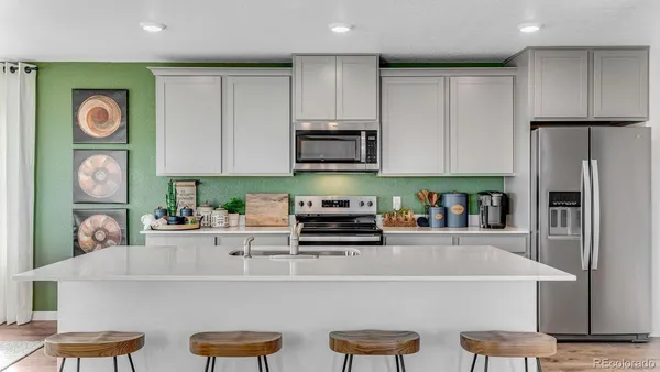 a kitchen with stainless steel appliances granite countertop a refrigerator and a stove top oven