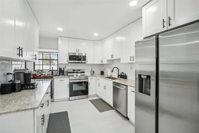 a kitchen with cabinets stainless steel appliances and a counter top space