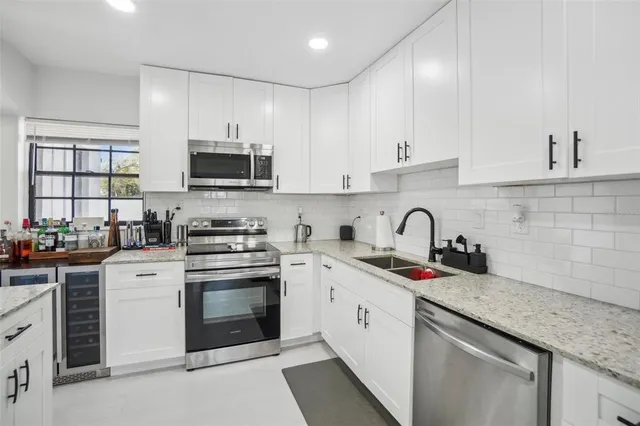 a kitchen with stainless steel appliances granite countertop a sink and cabinets