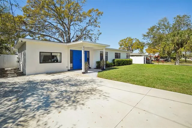 a front view of a house with a garden and trees