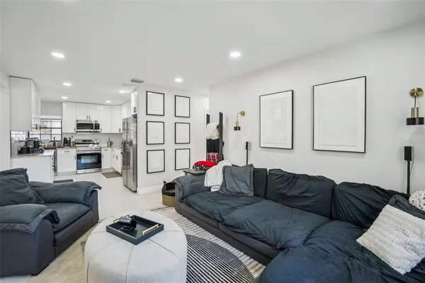 a living room with furniture kitchen view and a refrigerator