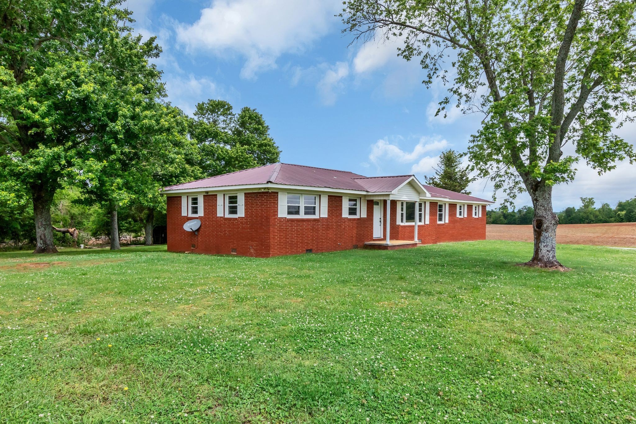 a view of a yard in front of a house with large trees