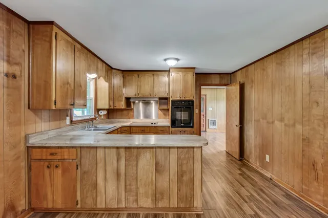 a kitchen with kitchen island granite countertop wooden cabinets a sink and stainless steel appliances