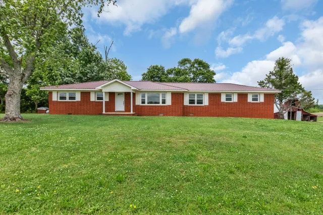 a view of a house with a yard and potted plants
