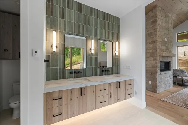 a spacious bathroom with a double vanity sink a mirror and a shower