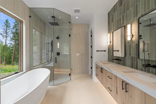 a bathroom with a large tub a shower and view