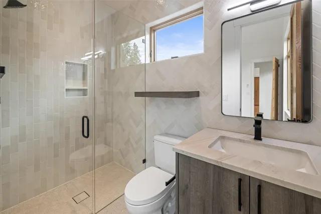 a bathroom with a sink toilet vanity and shower