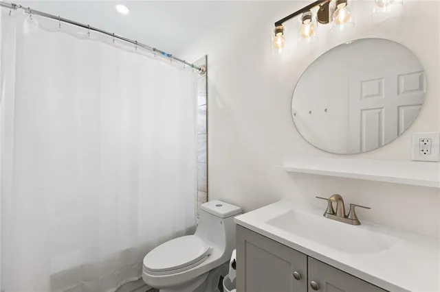 a bathroom with a sink a toilet and a mirror