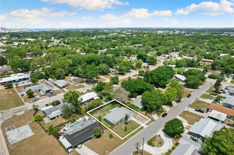 an aerial view of residential houses with outdoor space and trees
