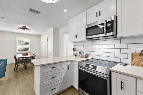 a kitchen with stainless steel appliances a stove microwave and cabinets