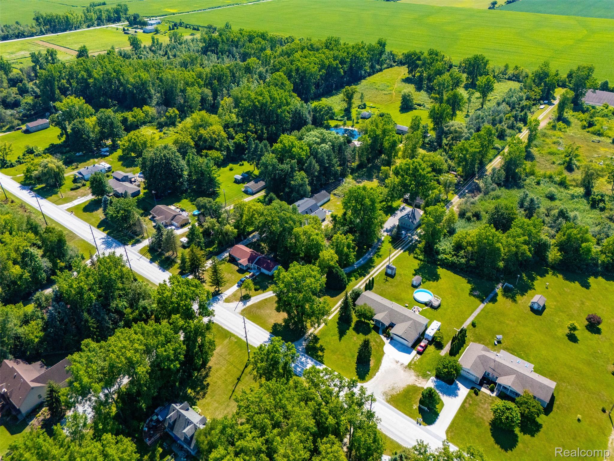 5161 Parker Road Fort Gratiot, MI 48059 - Photo 64 of 64 Aerial view of this multi-acre residential property showcasing mature tree-lined grounds, multiple residences, paved driveways, and expansive manicured lawns throughout the estate