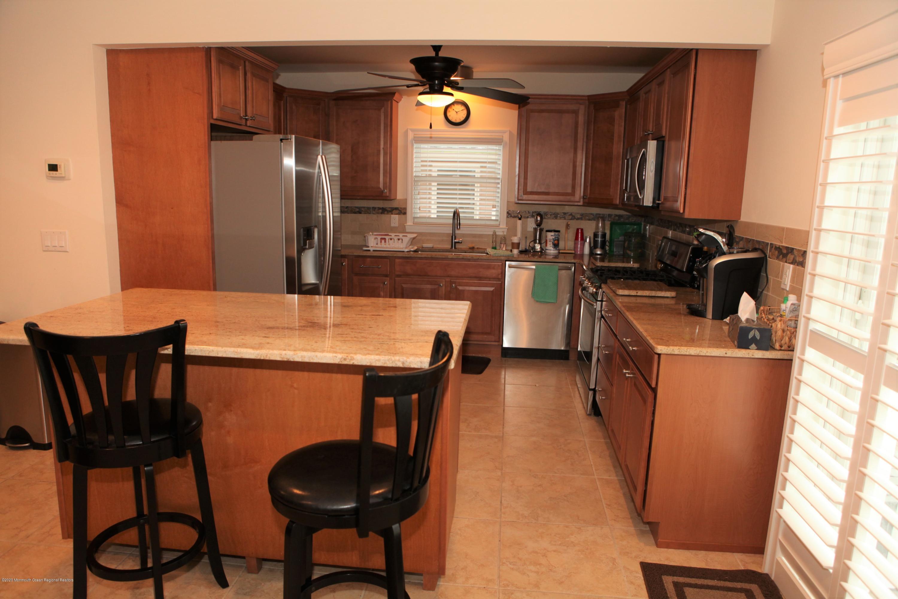 17 Colony Road Seaside Heights, NJ 08751 - Photo 22 of 37 a kitchen with refrigerator a stove a sink and chairs