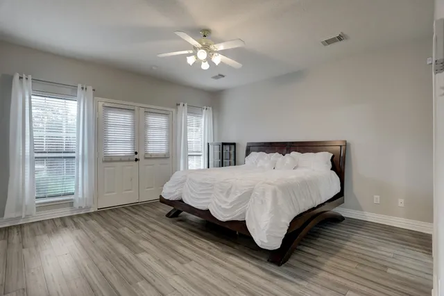 a spacious bedroom with a bed and a chandelier