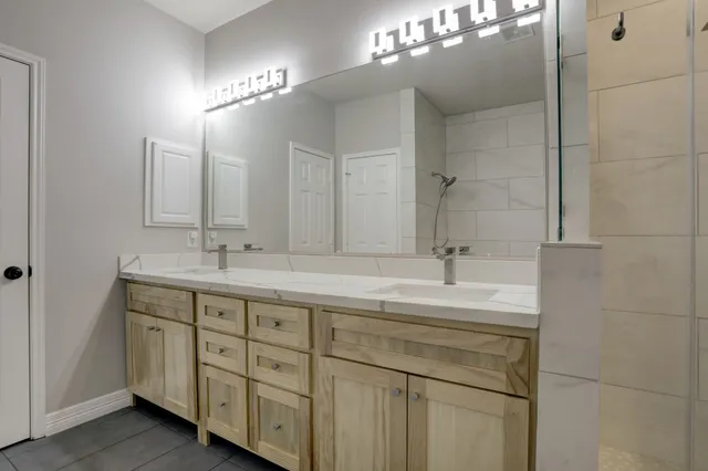 a bathroom with a double vanity sink and a mirror