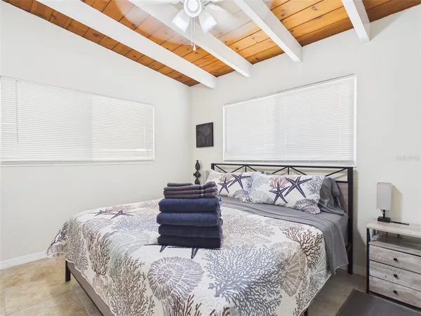 a large bed sitting in a bedroom next to a window