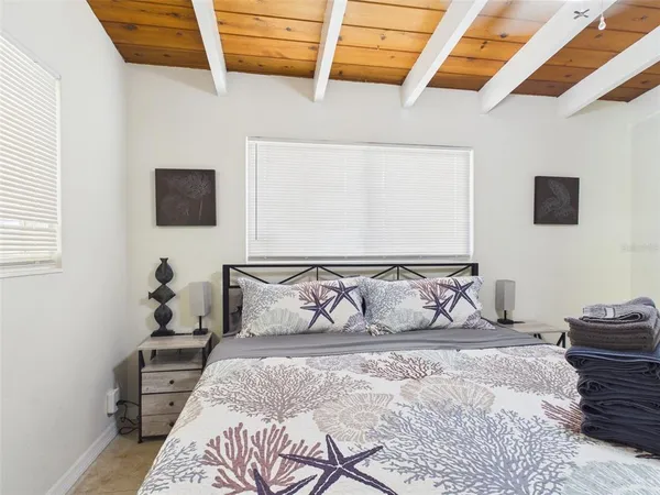 a bed sitting in a bedroom next to a window