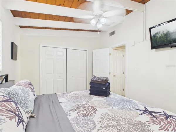 a bedroom with a bed and a flat screen tv