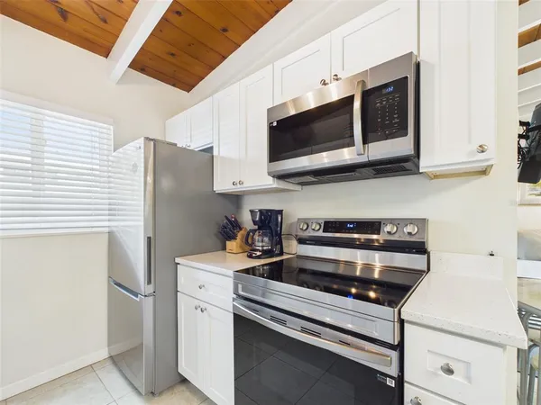 a kitchen with stainless steel appliances white cabinets and a refrigerator