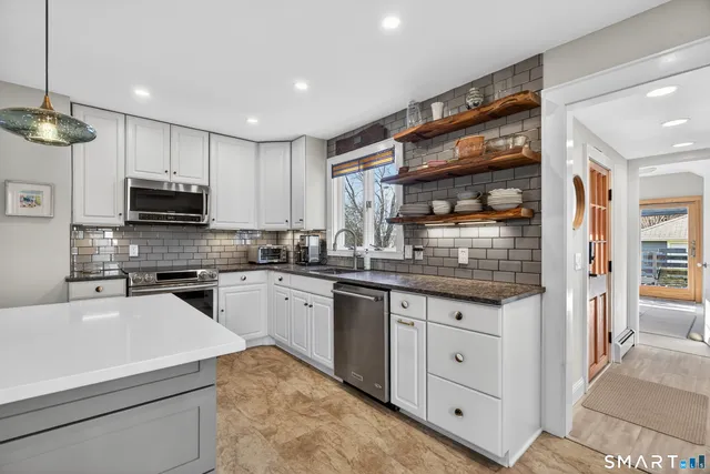 a kitchen with granite countertop appliances cabinets and a sink