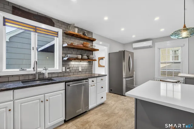 a kitchen with granite countertop a sink and refrigerator