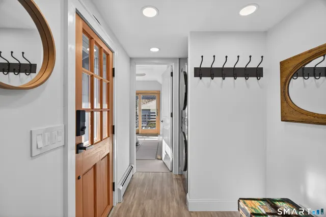 a view of a hallway with wooden floor and a bathroom