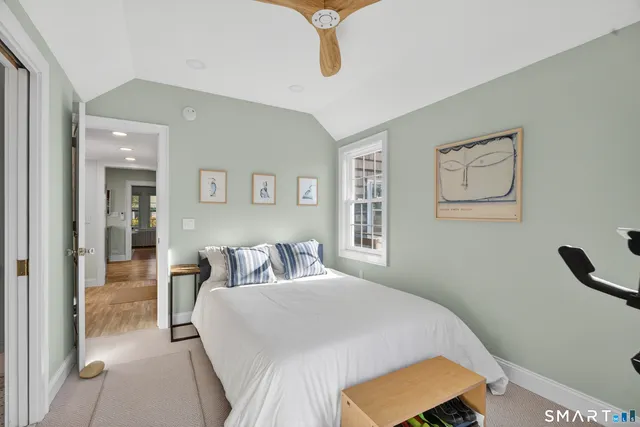 a bedroom with a bed and a lamp on dresser