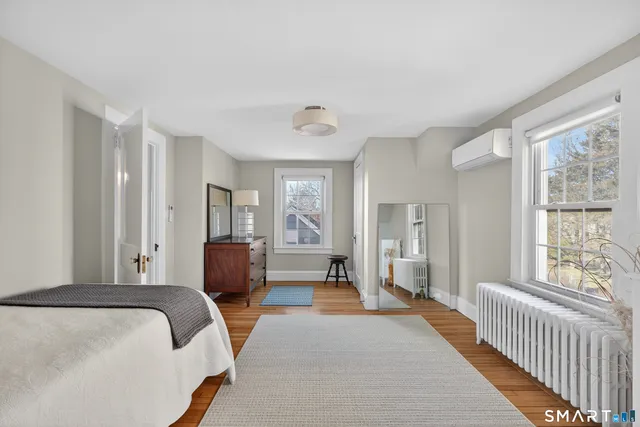 a bedroom with a balcony a bed and a large window