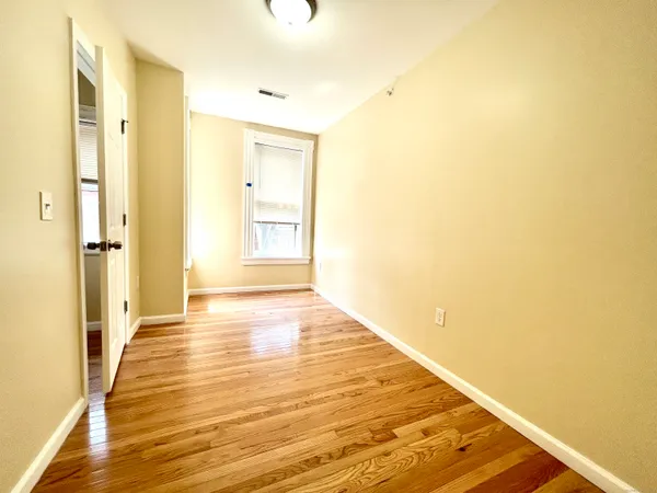 a view of an empty room with wooden floor